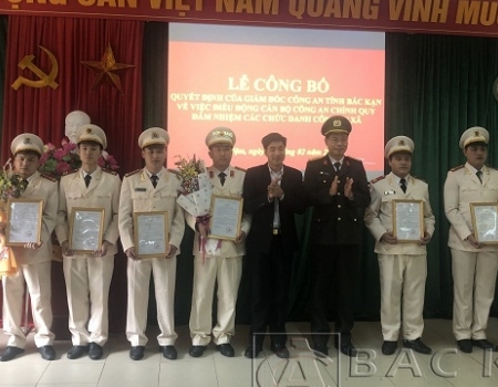 Thượng tá Vũ Văn Quân - PGĐ Công an tỉnh và đồng chí Nguyễn Đình Điệp, Chủ tịch UBND huyện Pác Nặm trao quyết định và tặng hoa chúc mừng các CBCS được bổ nhiệm các chức danh công an xã