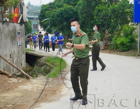 Cán bộ chiến sỹ Khối thi đua An ninh và bà con nhân dân thôn Nà Nàng thực hiện công trình Thắp sáng đường quê