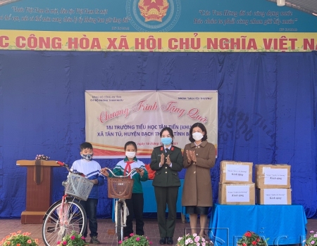 Đại diện Chi bộ phòng Tham mưu tặng quà cho nhà trường và xe đạp cho 2 em học sinh