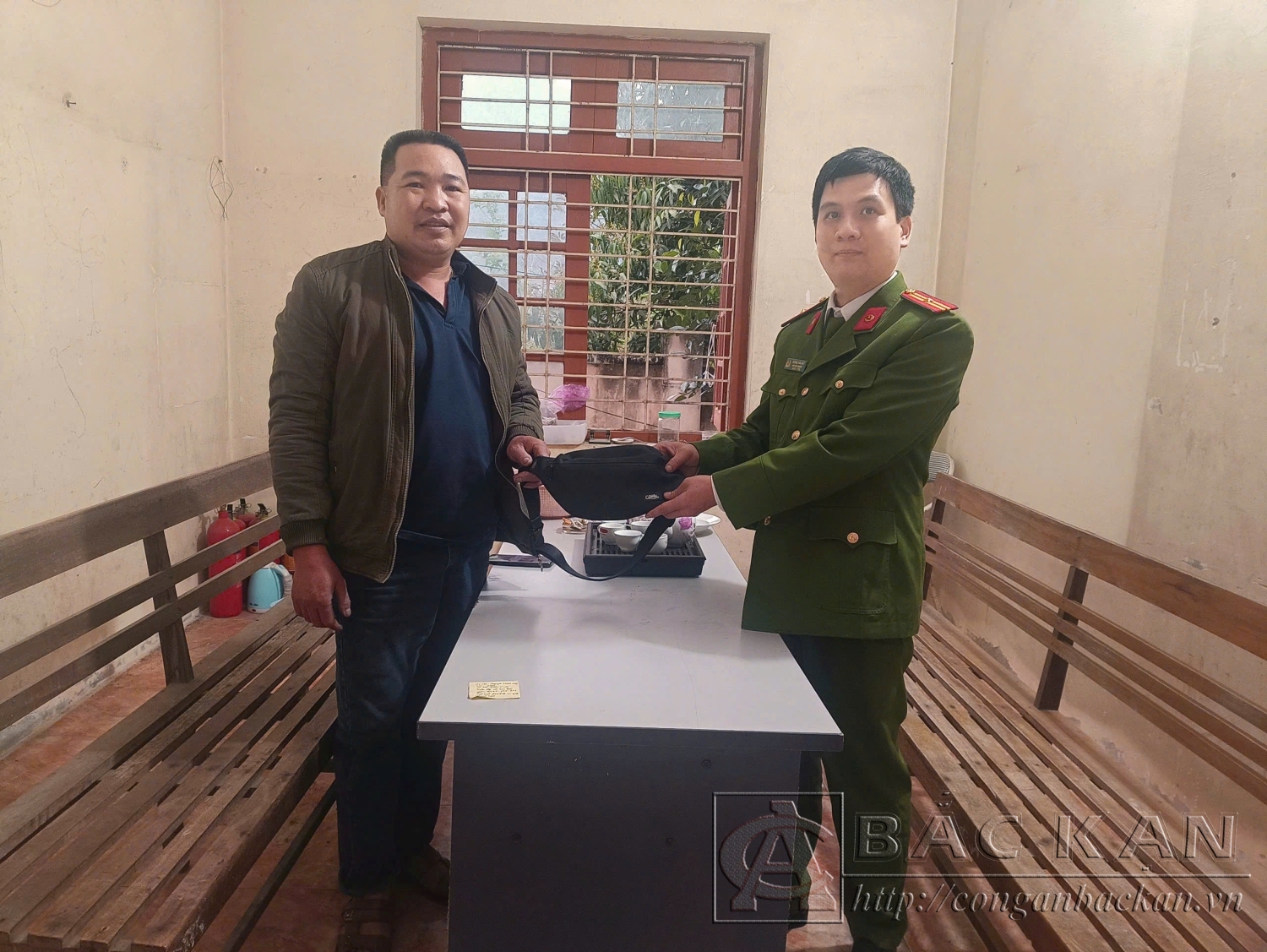 Thiếu tá Dương Văn Hiệt - Trưởng Công an xã Yến Dương tiếp nhận tài sản từ anh Nông Văn Duyến